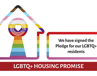 Rainbow-colored house icon with a heart symbol, alongside text stating 'We have signed the Pledge for our LGBTQ+ residents' and a red banner reading 'LGBTQ+ Housing Promise'.