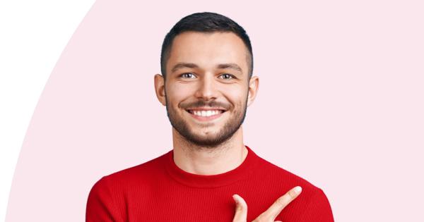 Person in a red sweater pointing to the right, against a light pink background with a white curved section on the left.