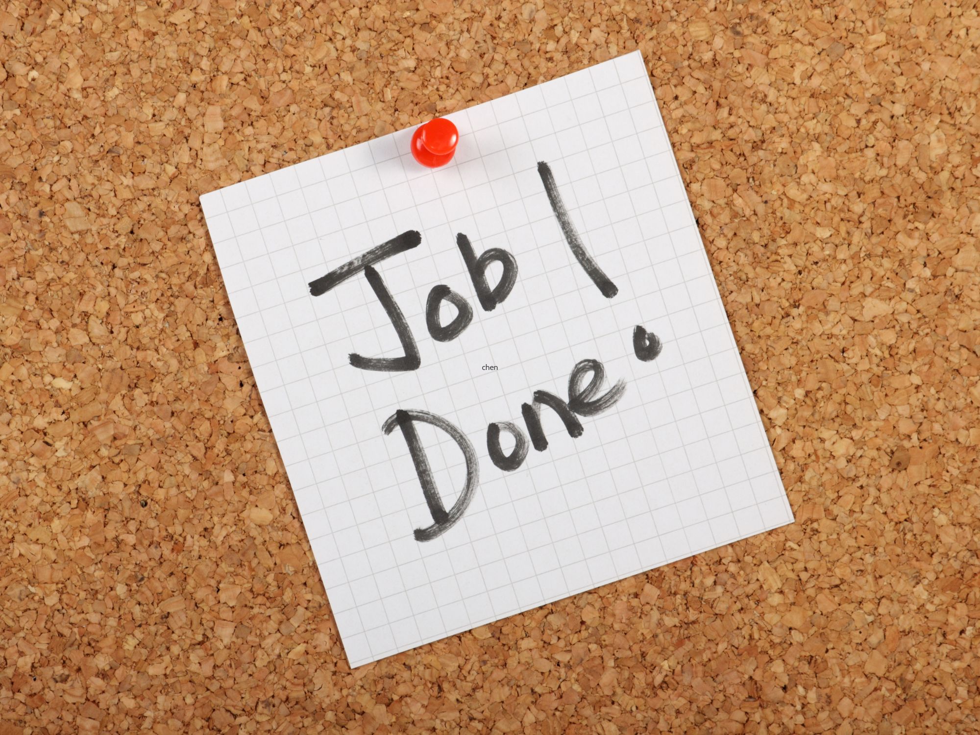 Graph paper pinned to a corkboard with a red pushpin, displaying the handwritten message 'Job! Done.' in black marker