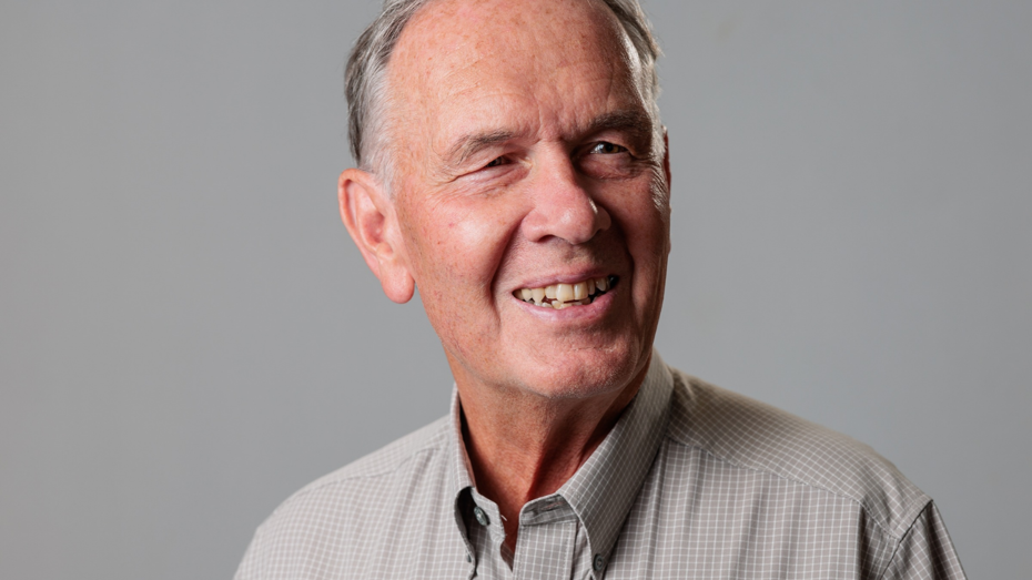 Portrait image of Clive Elliott, Chair of South Liverpool Homes against an neutral grey background