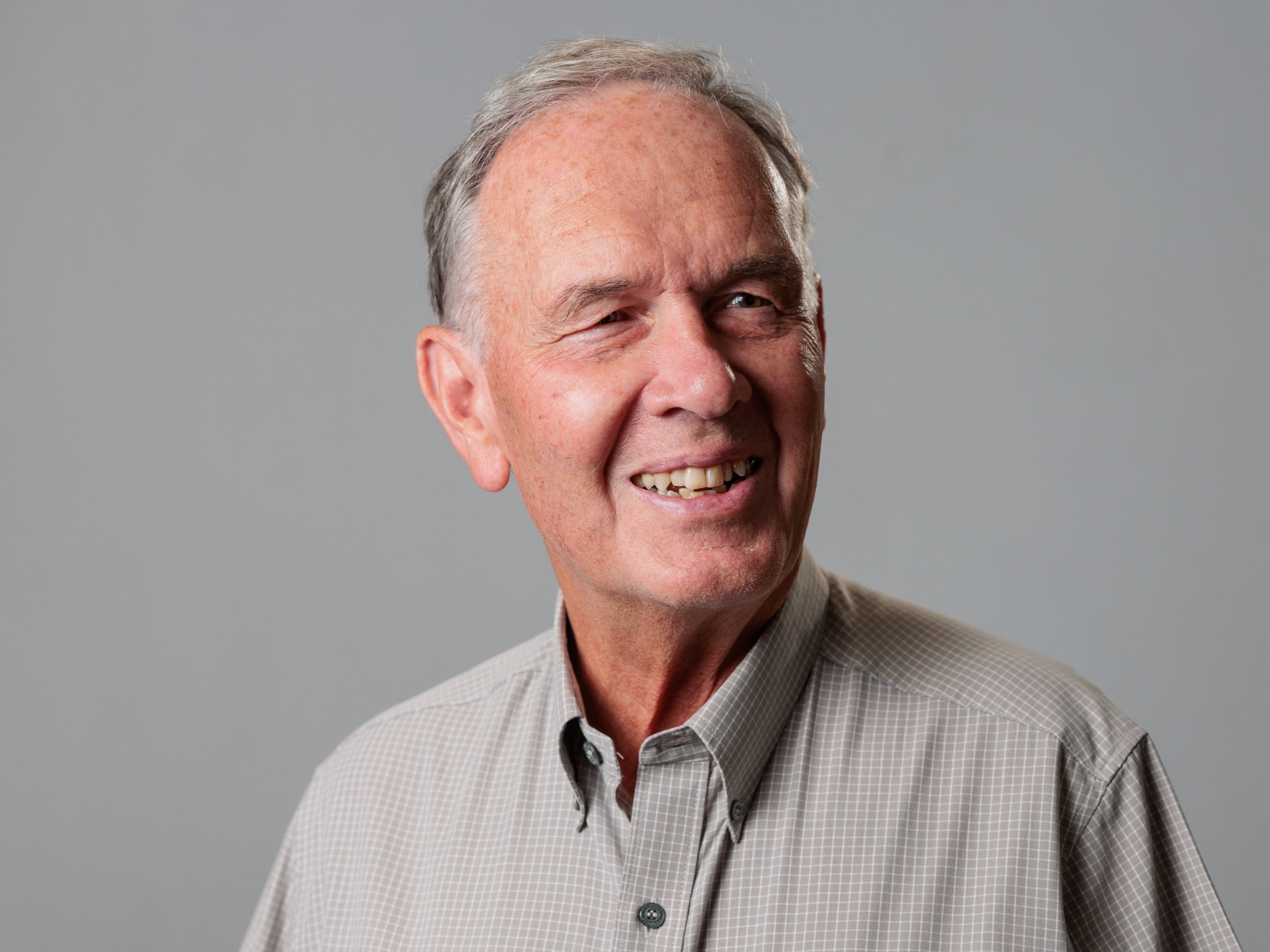 Portrait image of Clive Elliott, Chair of South Liverpool Homes against an neutral grey background