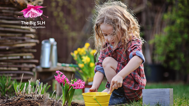 A child is sitting outdoors in a garden area, using a small trowel to dig soil near a yellow bucket. Pink hyacinth flowers are planted nearby, and gardening tools and plants can be seen in the background. On the left, a rounded text box says: “Got some spring planting questions? Come along to Grow Speke on Friday 10 April from 11am!” In the top right corner is The Big SLH Garden Competition logo, which includes a pink and purple fuchsia flower above the text.