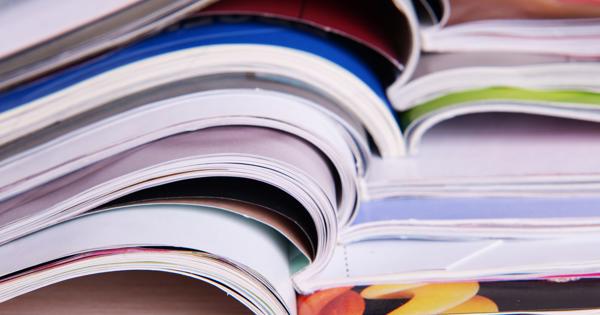A stack of open magazines fanned out, showing colourful pages and covers, representing a collection of publications.