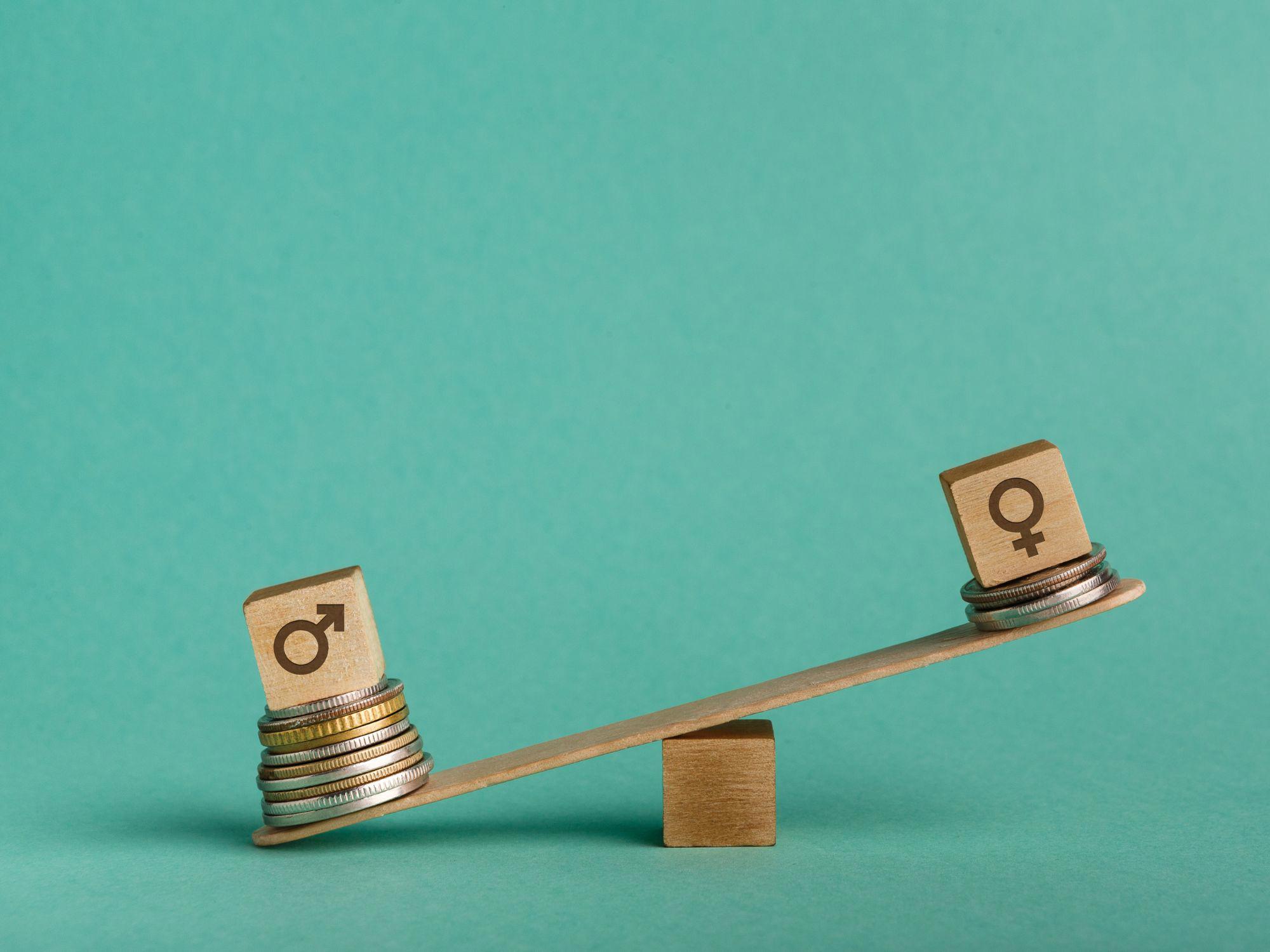 A seesaw with a male symbol block on a tall stack of coins and a female symbol block on a shorter stack, illustrating a financial imbalance.
