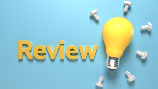 The word “Review” in bold yellow 3D letters on a light blue background, next to a yellow light bulb surrounded by bolts, symbolizing ideas and constructive evaluation.