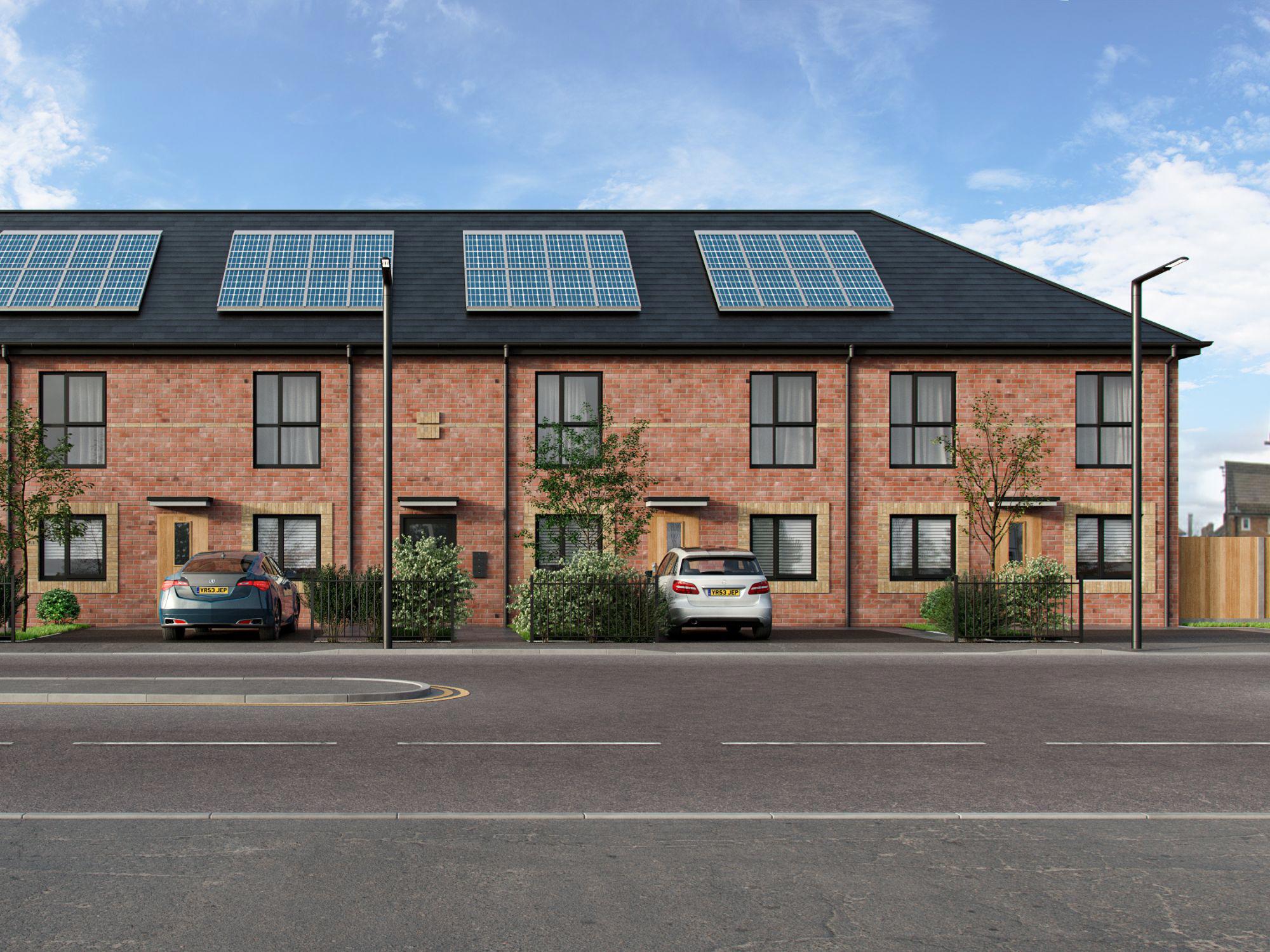 A two-storey apartment block with black roof and rooftop solar panels. A blue and a white car are parked in front, with streetlights lining the empty road under a partly cloudy sky.