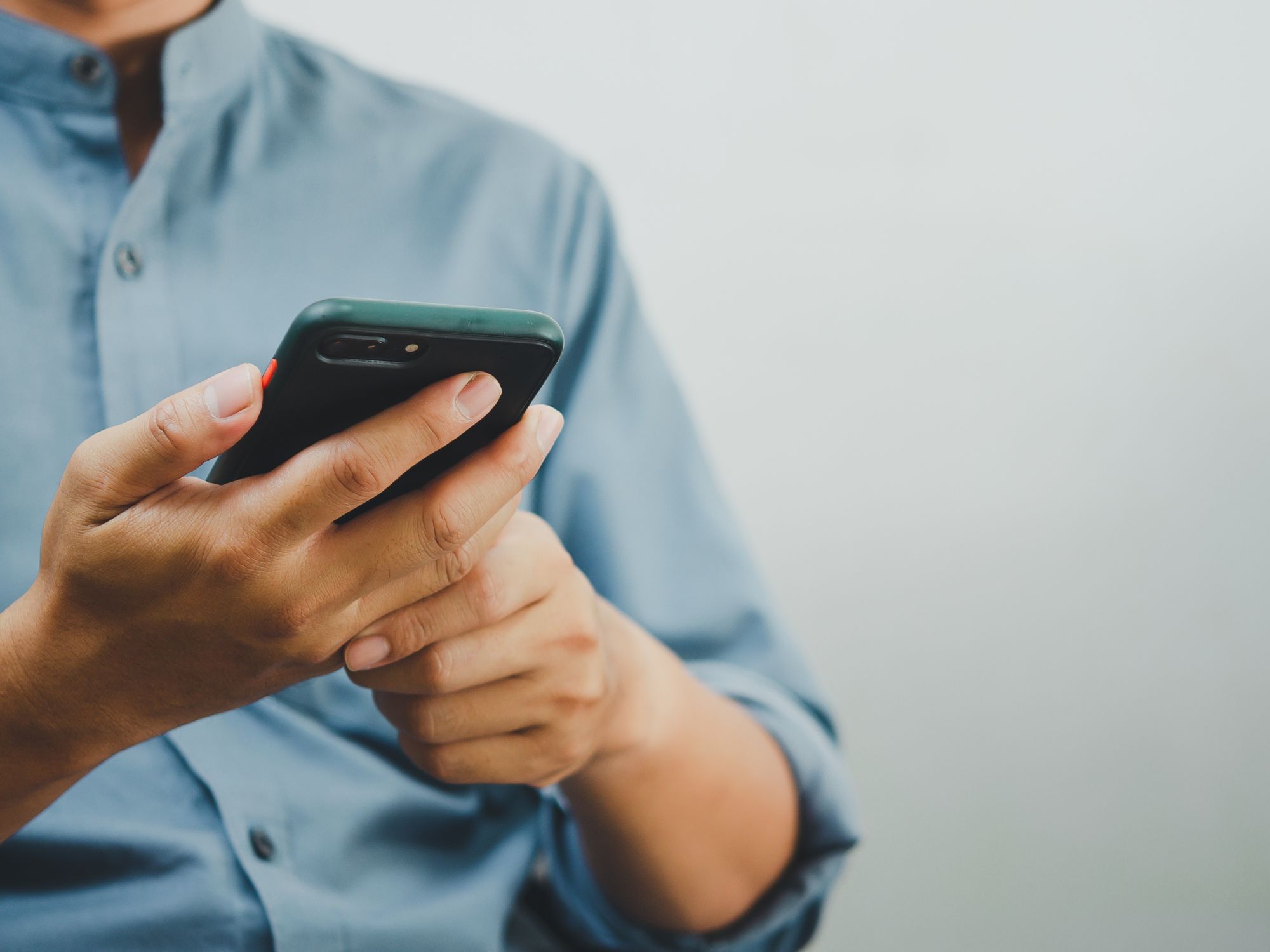 Person using a smartphone, representing how residents can report anti-social behaviour online quickly and easily.
