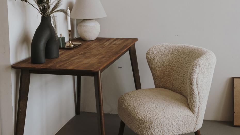 A cosy wooden desk setup with decorative items like vases, candles, and a lamp in a warmly lit corner. A cosy wooden desk setup with decorative items like vases, candles, and a lamp in a warmly lit corner.