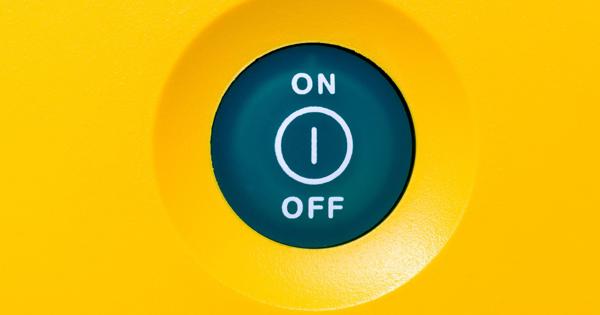 Close-up of a circular green switch on a yellow panel, labeled 'ON' at the top with a line symbol and 'OFF' at the bottom with a circle symbol.