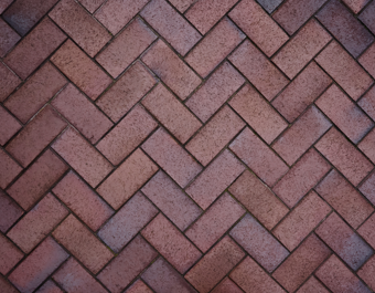 An aerial view of a section of red herringbone brick paving.
