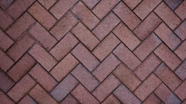 An aerial view of a section of red herringbone brick paving.