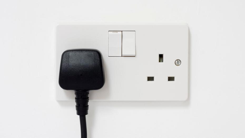 White electrical wall socket with two switches; a black plug is inserted into the left socket, while the right socket is empty. White electrical wall socket with two switches; a black plug is inserted into the left socket, while the right socket is empty.