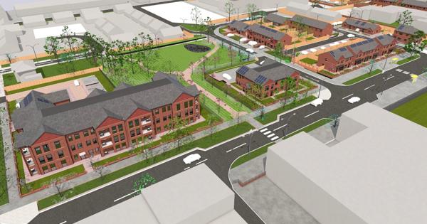 Aerial view of a planned residential development featuring red brick multi-story buildings, smaller homes with solar panels, organized streets, crosswalks, sidewalks, and landscaped green spaces with trees and grass.