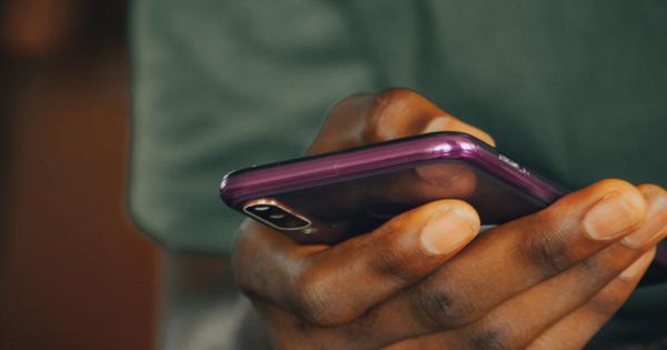Close-up of a hand holding a smartphone with a purple case, actively using the device. The background is blurred to emphasize the phone and hand.