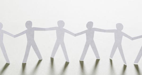 Paper cut-out figures holding hands in a chain, symbolising unity, collaboration, and community safety.