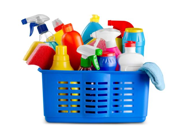Blue plastic basket containing assorted cleaning supplies including spray bottles, sponges, liquid containers, and a cloth in various colours. Blue plastic basket containing assorted cleaning supplies including spray bottles, sponges, liquid containers, and a cloth in various colours.