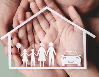 Hands gently holding a paper cut-out of a house containing simple figures of a family and a car, symbolising protection, support and home.