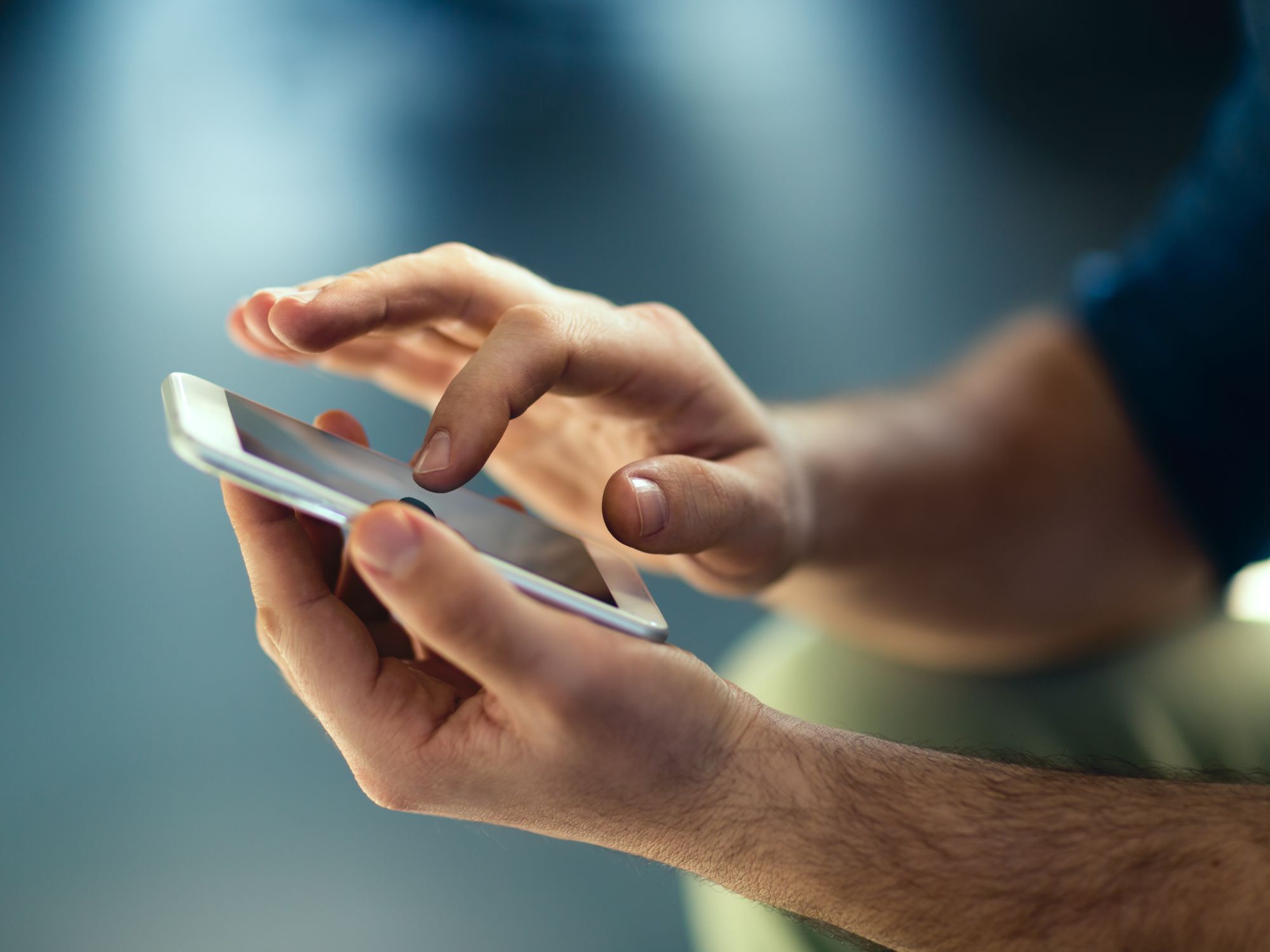 Close-up of hands using a smartphone, suggesting digital communication. 