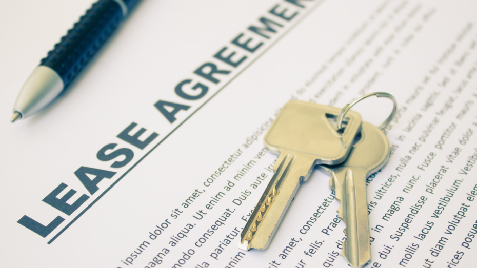 Keys resting on a lease agreement document, with a pen in the background.
