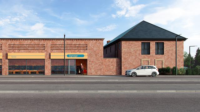 Street view of a brick building complex with a storefront featuring yellow awnings and signage. Two people stand near the entrance, and a white car is parked in front of a two-storey building under a partly cloudy sky.